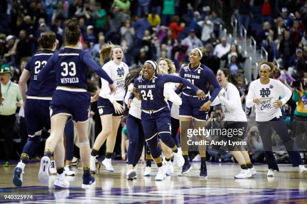 Arike Ogunbowale of the Notre Dame Fighting Irish is congratulated by her teammates after hitting the game winning basket to defeat the Connecticut...