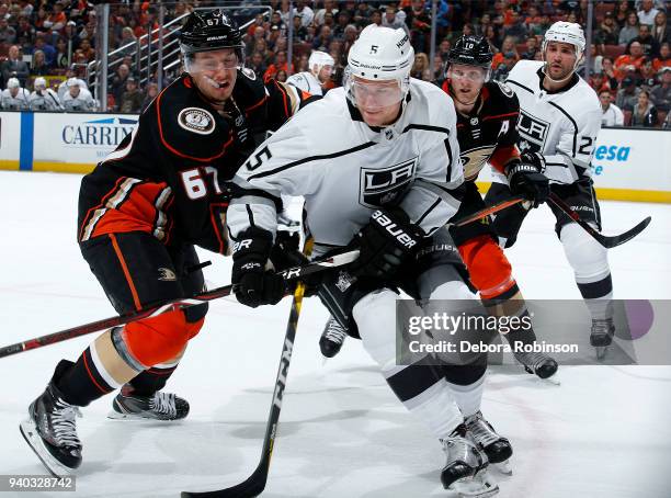 Christian Folin of the Los Angeles Kings battles for the puck against Rickard Rakell of the Anaheim Ducks as Alec Martinez of the Los Angeles Kings...