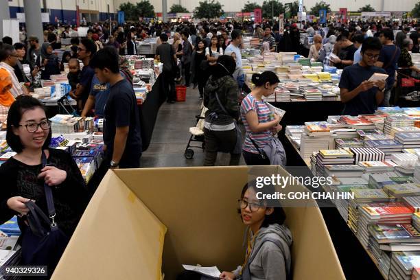 This picture taken on March 30, 2018 shows people browsing through books at the Big Bad Wolf book sale in Serpong in the suburbs of Jakarta. / AFP...