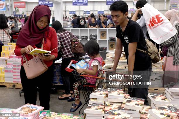 This picture taken on March 30, 2018 shows families browsing through books at the Big Bad Wolf book sale in Serpong in the suburbs of Jakarta. / AFP...