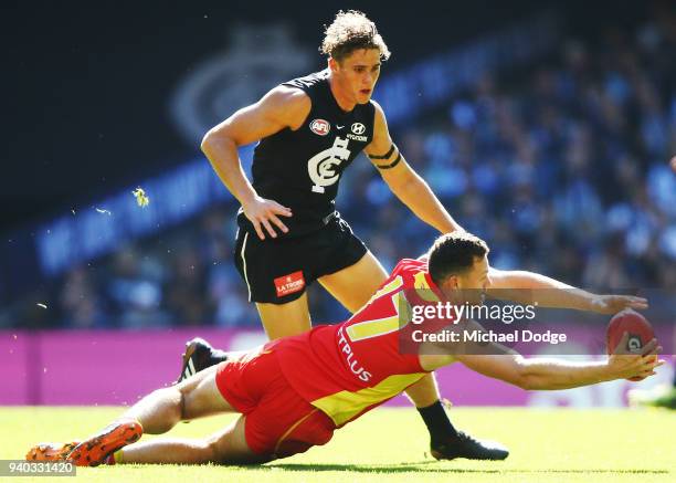 Steven May of the Suns dives for the ball against Charlie Curnow of the Blues during the round two AFL match between the Carlton Blues and the Gold...