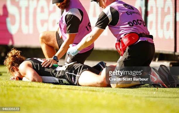 Tim Broomhead of the Magpies lies on the field with a broken leg during the round two AFL match between the Collingwood Magpies and the Greater...