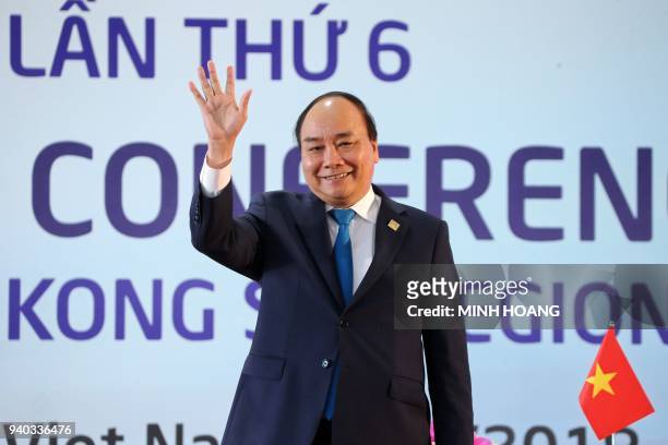 Vietnam's Prime Minister Nguyen Xuan Phuc waves as he leaves a press conference after the Greater Mekong Subregion Summit in Hanoi on March 31, 2018....
