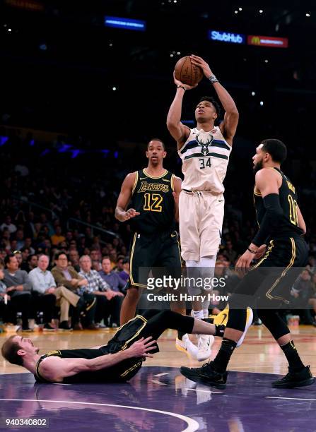 Giannis Antetokounmpo of the Milwaukee Bucks attempts a shot after he is fouled by Alex Caruso of the Los Angeles Lakers as Channing Frye and Tyler...