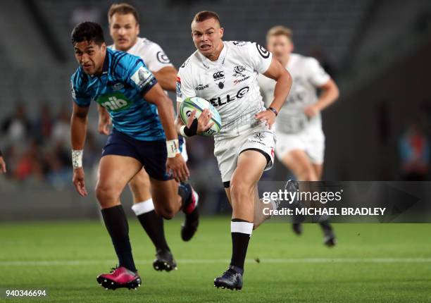 Curwin Bosch of the Sharks breaks away from Reiko Ioane of the Blues during the Super Rugby match between the Auckland Blues of New Zealand and the...