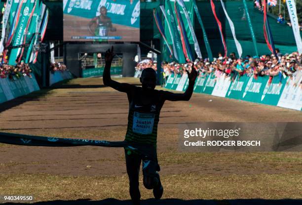 Kenya's Justin Kemboi Chesire raises his arms as he crosses the finish line, winning the men's section of the Two Oceans ultra-marathon, on March 31...