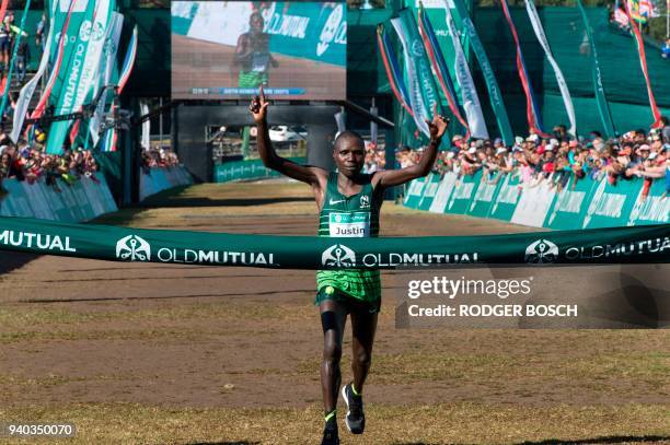 Kenya's Justin Kemboi Chesire raises his arms as he crosses the finish line, winning the men's section of the Two Oceans ultra-marathon, on March 31...