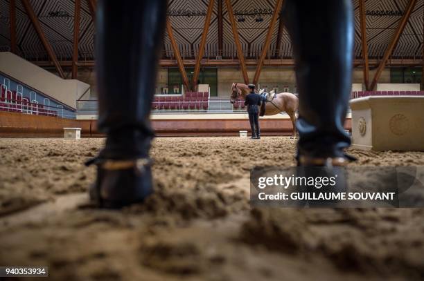 Man stands near a horse during a training day at the "Cadre Noir de Saumur" national equestrian school on February 28 in Saumur, western France. /...
