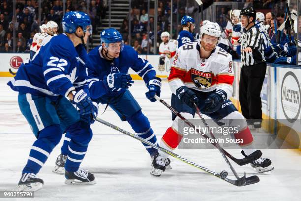 Mike Matheson of the Florida Panthers battles for the puck against Zach Hyman of the Toronto Maple Leafs and Nikita Zaitsev during the first period...
