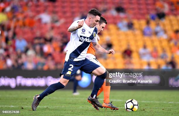 Matthew McKay of the Roar is challenged by Storm Roux of the Mariners during the round 25 A-League match between the Brisbane Roar and the Central...