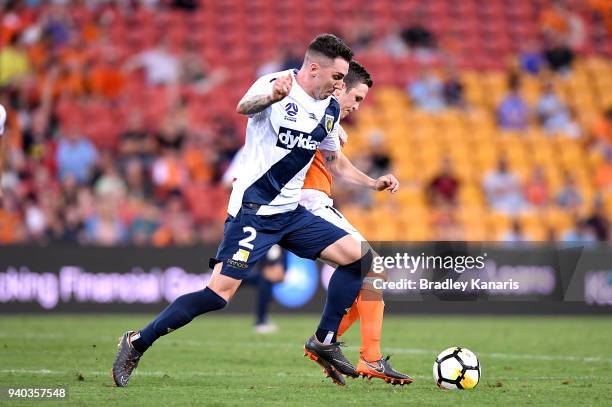 Matthew McKay of the Roar is challenged by Storm Roux of the Mariners during the round 25 A-League match between the Brisbane Roar and the Central...