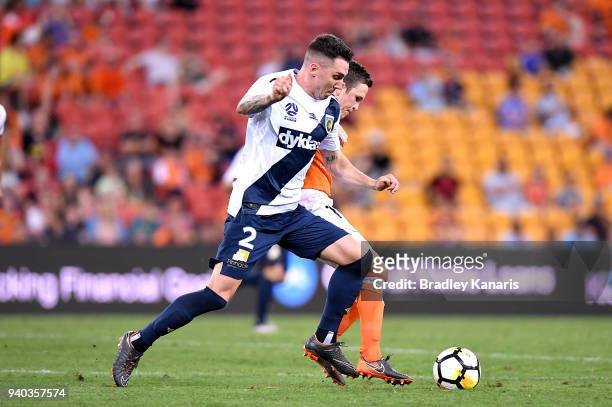Matthew McKay of the Roar is challenged by Storm Roux of the Mariners during the round 25 A-League match between the Brisbane Roar and the Central...