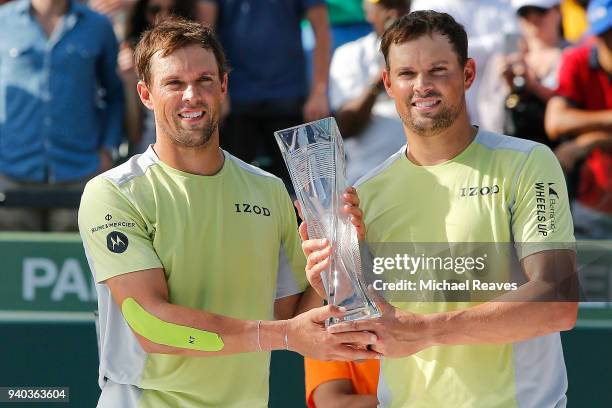 Bob Bryan and Mike Bryan pose for a photo with the Miami Open trophy after defeating Karen Khachanov and Andrey Rublev of Russia during the men's...