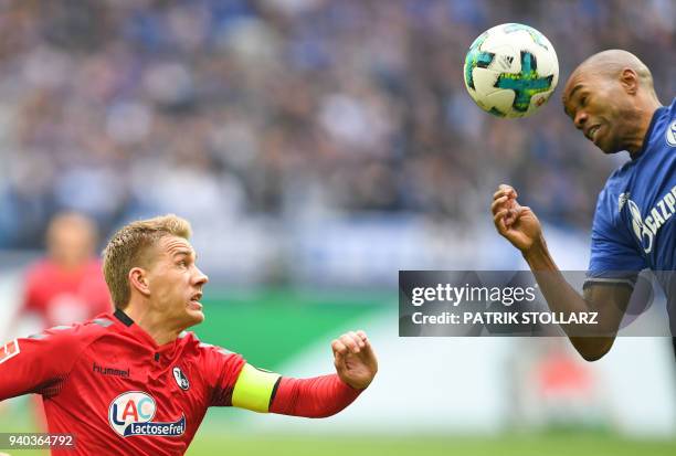 Freiburg's German forward Nils Petersen and Schalke's Brazilian defender Naldo vie for the ball during the German first division Bundesliga football...