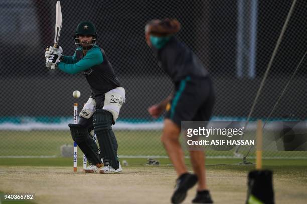Pakistan's cricketer Ahmed Shehzad plays a shot plays a shot during a team practice at the National Cricket Stadium in Karachi on March 31, 2018 on...