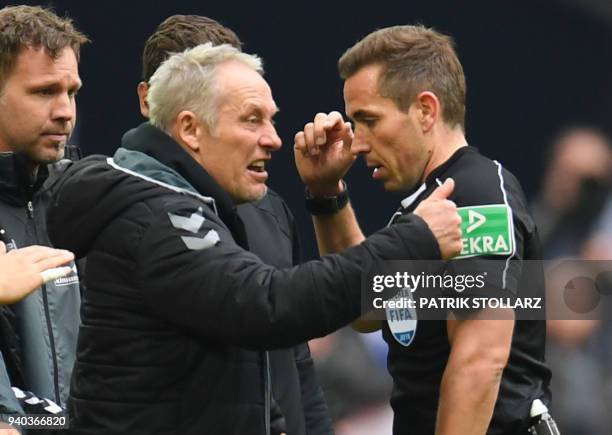 Freiburg's German head coach Christian Streich debates with referee Tobias Stieler during the German first division Bundesliga football match FC...