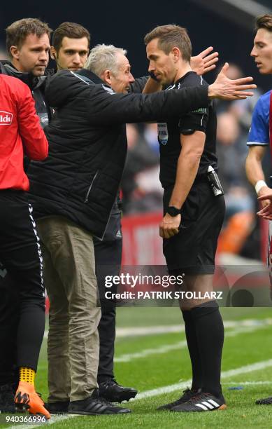 Freiburg's German head coach Christian Streich debates with referee Tobias Stieler during the German first division Bundesliga football match FC...