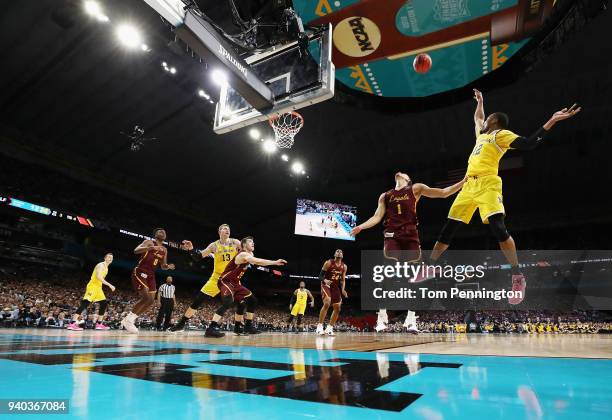 Muhammad-Ali Abdur-Rahkman of the Michigan Wolverines shoots against Lucas Williamson of the Loyola Ramblers in the first half during the 2018 NCAA...