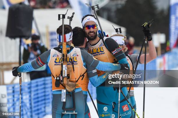 France's Martin Fourcade celebrates with teammates after competing in the mass start Premanon French Biathlon Championships on March 31, 2018 in...