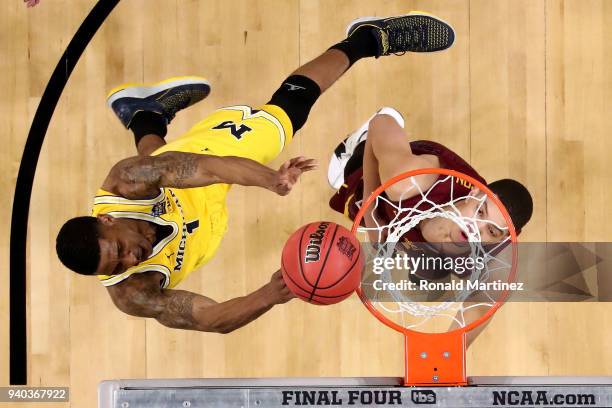 Charles Matthews of the Michigan Wolverines drives to the basket in the secold half against Lucas Williamson of the Loyola Ramblers during the 2018...