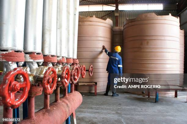 An employee of the "Pesca Fresca" fish factory checks fish storage tanks on February 12, 2018 in the Angolan coastal city of Benguela. - Angolan...