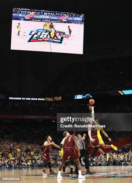 Isaiah Livers of the Michigan Wolverines and Cameron Krutwig of the Loyola Ramblers go up for the opening tip during the 2018 NCAA Men's Final Four...