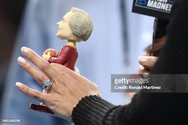 Personality Tracy Wolfson holds a bobblehead of Loyola Ramblers team chaplain Sister Jean Dolores-Schmidt in the first half against the Michigan...