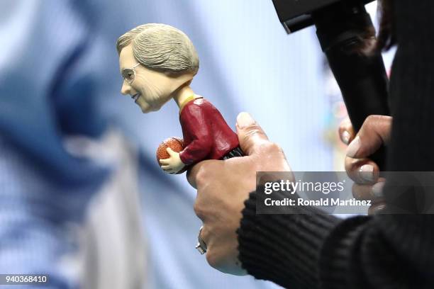 Personality Tracy Wolfson holds a bobblehead of Loyola Ramblers team chaplain Sister Jean Dolores-Schmidt in the first half against the Michigan...