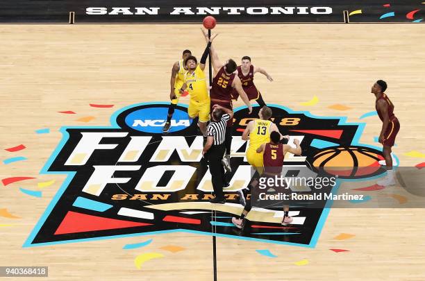 Isaiah Livers of the Michigan Wolverines and Cameron Krutwig of the Loyola Ramblers go up for the opening tip during the 2018 NCAA Men's Final Four...