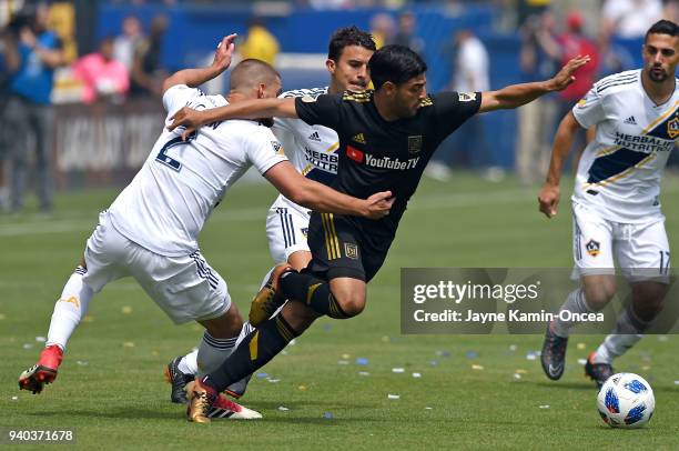 Perry Kitchen of Los Angeles Galaxy defends Carlos Vela of Los Angeles FC as they chase down the ball in the first half of the game at StubHub Center...