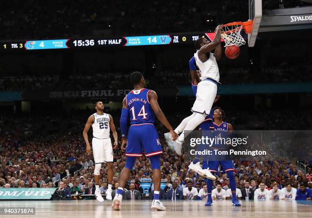 Eric Paschall of the Villanova Wildcats dunks in the first half against Malik Newman and Devonte' Graham of the Kansas Jayhawks during the 2018 NCAA...