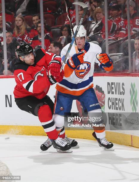 Patrick Maroon of the New Jersey Devils and Dennis Seidenberg of the New York Islanders come together near the boards during the game at Prudential...