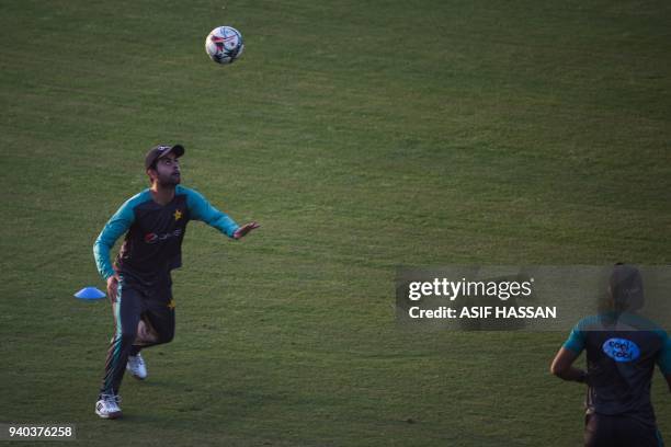 Pakistan cricket team player Ahmed Shehzad eyes a ball during a soccer team practice at the National Cricket Stadium in Karachi on March 31, 2018 on...