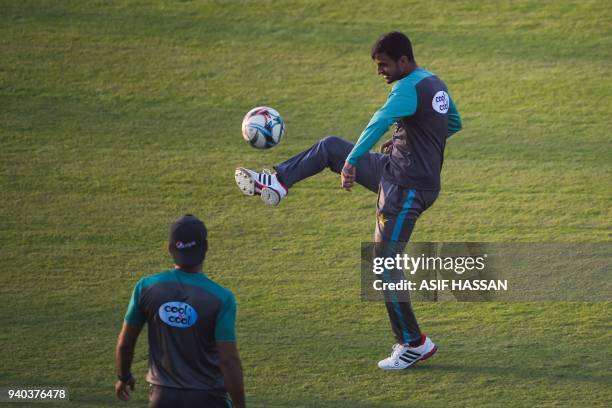 Pakistan cricketer Shoaib Malik kicks a ball during a soccer team practice at the National Cricket Stadium in Karachi on March 31, 2018 on the eve of...