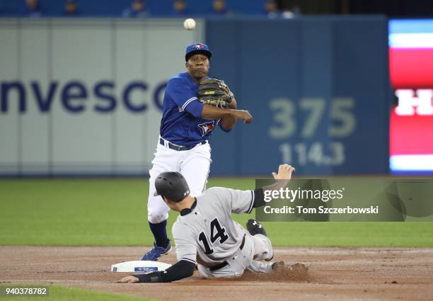 Gift Ngoepe of the Toronto Blue Jays turns a double play in the first inning during MLB game action as Neil Walker of the New York Yankees slides...