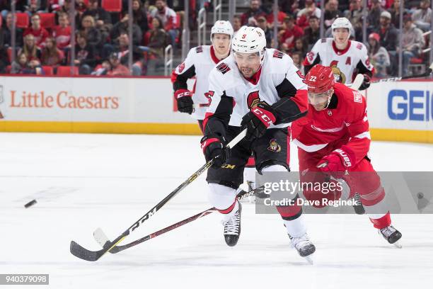 Cody Ceci of the Ottawa Senators races after the puck followed by Andreas Athanasiou of the Detroit Red Wings during an NHL game at Little Caesars...