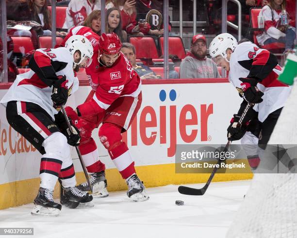 Jean-Gabriel Pageau of the Ottawa Senators skates with the puck as teammate Tom Pyatt battles along the boards with Jonathan Ericsson of the Detroit...