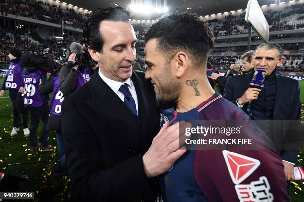 Paris Saint-Germain's Spanish headcoach Unai Emery embraces Paris Saint-Germain's Brazilian defender Daniel Alves as they celebrate after victory in...