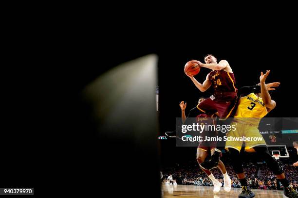 Ben Richardson of the Loyola Ramblers attempts a shot defended by Zavier Simpson of the Michigan Wolverines in the 2018 NCAA Photos via Getty Images...