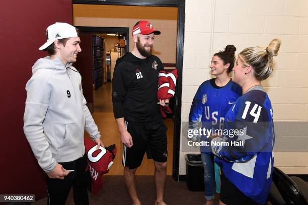 Derek Stepan and Clayton Keller of the Arizona Coyotes take a picture with Brianna Decker and Amanda Pelkey, members of the 2018 United States...