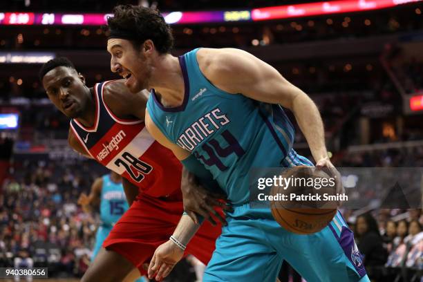 Frank Kaminsky of the Charlotte Hornets dribbles past Ian Mahinmi of the Washington Wizards during the second half at Capital One Arena on March 31,...