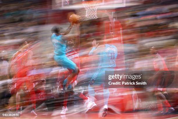 Dwayne Bacon of the Charlotte Hornets shoots in front of Ian Mahinmi of the Washington Wizards during the second half at Capital One Arena on March...