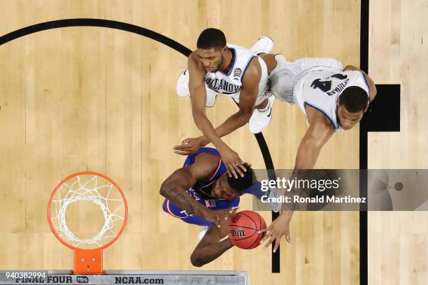 Silvio De Sousa of the Kansas Jayhawks drives to the basket against Mikal Bridges and Omari Spellman of the Villanova Wildcats in the first half...