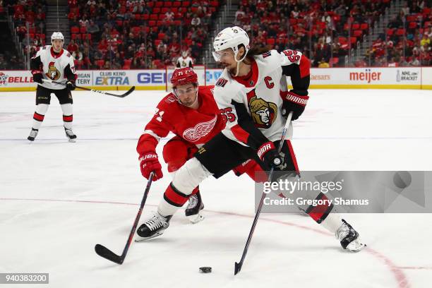 Erik Karlsson of the Ottawa Senators tries to control the puck in front of Dylan Larkin of the Detroit Red Wings during the third period at Little...