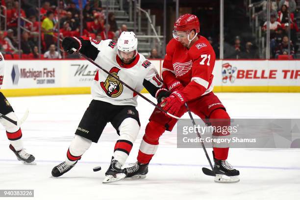 Dylan Larkin of the Detroit Red Wings battles for the puck with Tom Pyatt of the Ottawa Senators during the first period at Little Caesars Arena on...