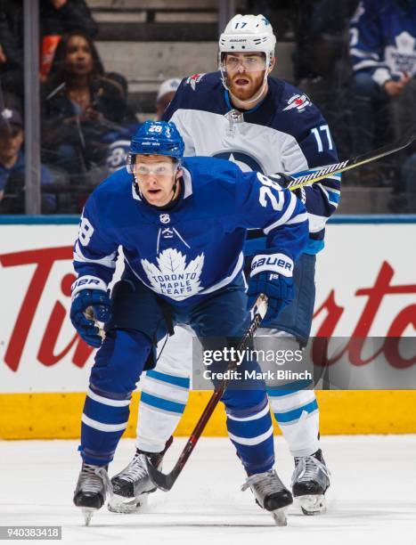 Connor Brown of the Toronto Maple Leafs skates against Adam Lowry of the Winnipeg Jets during the first period at the Air Canada Centre on March 31,...