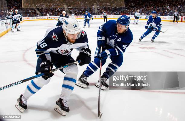 Morgan Rielly of the Toronto Maple Leafs skates against Bryan Little of the Winnipeg Jets during the second period at the Air Canada Centre on March...