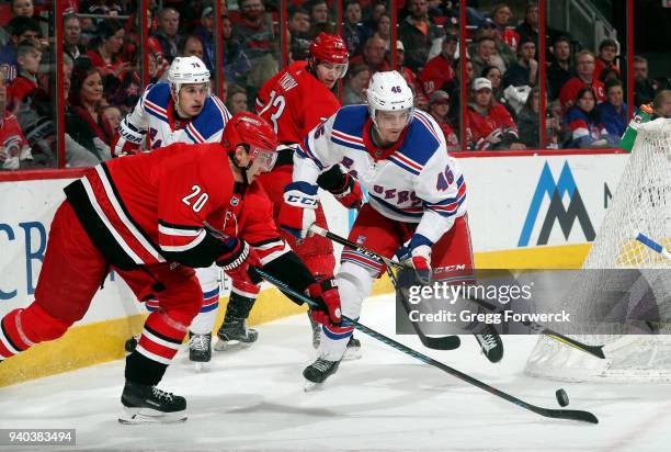 Sebastian Aho of the Carolina Hurricanes collects a loose puck ahead of Rob O'Gara of the New York Rangers during an NHL game on March 31, 2018 at...