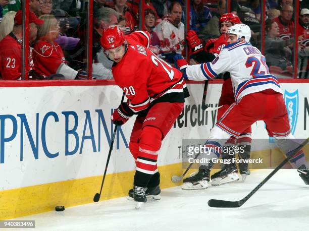 Sebastian Aho of the Carolina Hurricanes defends the puck along the end boards during an NHL game against the New York Rangers on March 31, 2018 at...