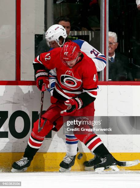 Joakim Nordstrom of the Carolina Hurricanes and Ryan Spooner of the New York Rangers battle for a loose puck during an NHL game on March 31, 2018 at...